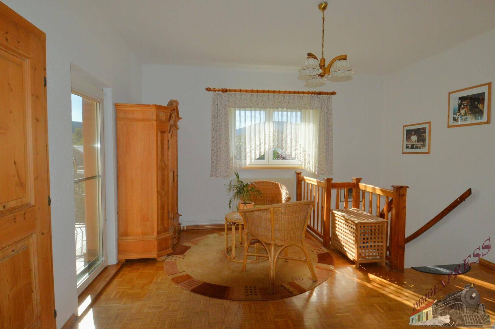Geräumiges Zimmer mit Holzboden, traditionellen Möbeln und Balkonzugang, lichtdurchflutet.