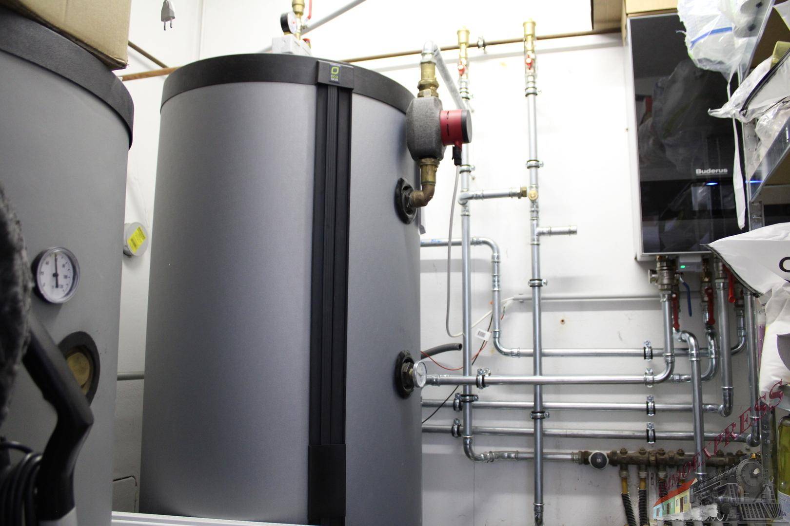 Moderner Heizungsraum mit großen Warmwasserspeichern und komplexer Rohrinstallation von Buderus.