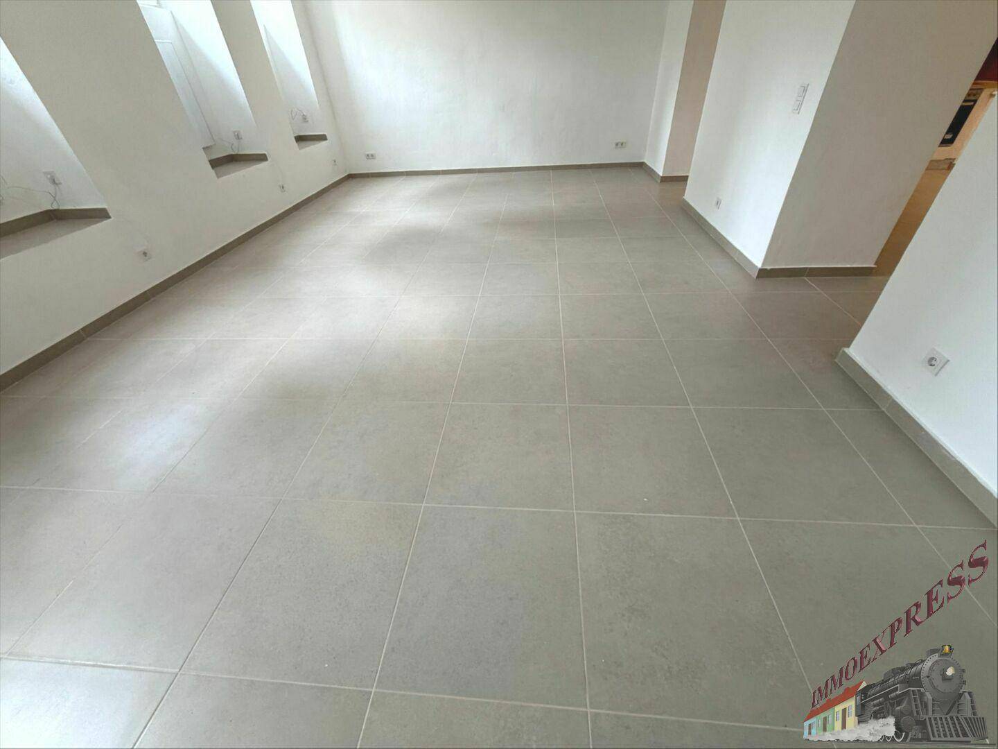 Großer, heller Raum mit Fliesenboden und schrägen Wänden, der vielseitig genutzt werden kann.