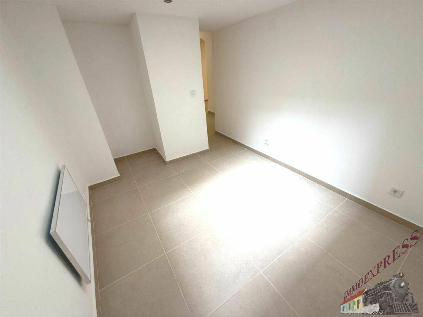 Kleiner, heller Raum mit Fliesenboden und weiß gestrichenen Wänden, ideal als Schlaf- oder Arbeitszimmer.