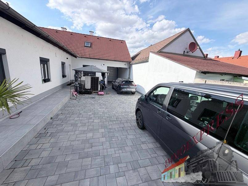 Weitläufige gepflasterte Einfahrt mit Parkmöglichkeiten und Blick auf das Wohnhaus.