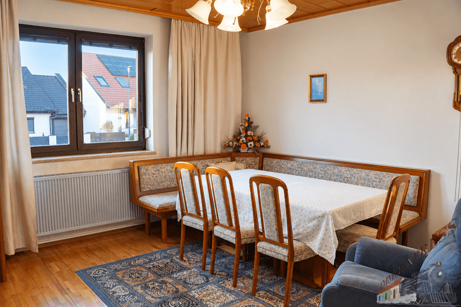 Geräumiges Esszimmer mit großem Holztisch, Eckbank und Blick auf die Nachbarschaft.