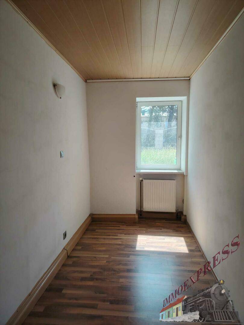 Kleiner Raum mit Holztäfelung an der Decke, Laminatboden und einem Fenster.