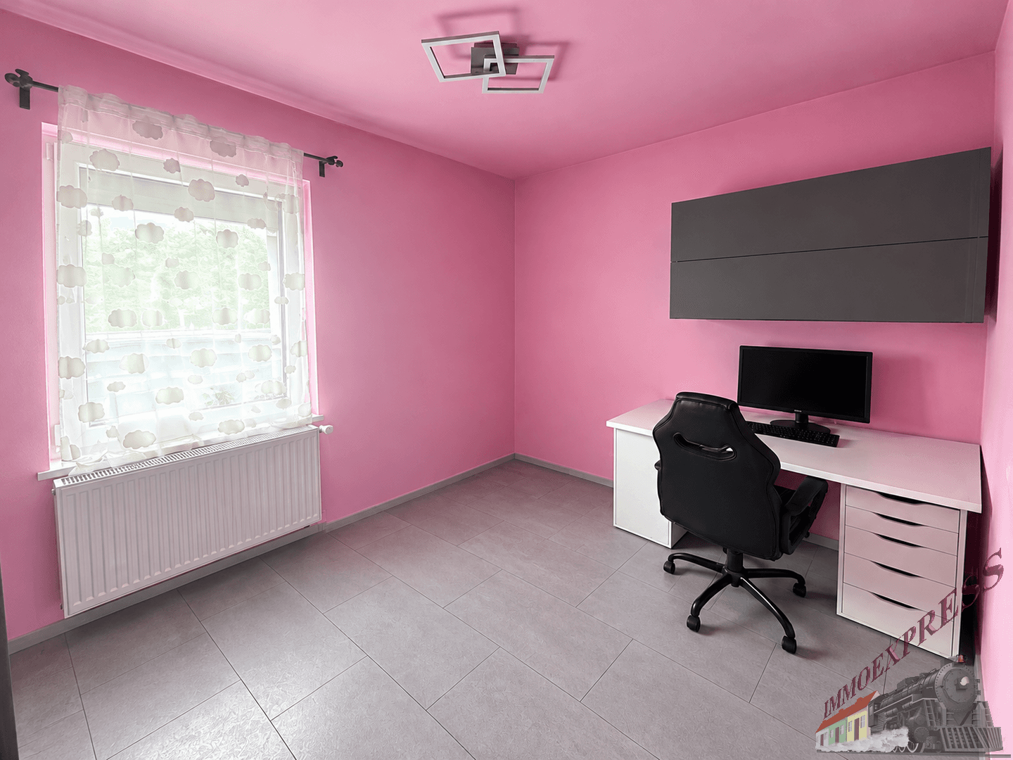 Arbeitszimmer mit rosa Wänden, Schreibtisch, Bürostuhl und Fliesenboden.