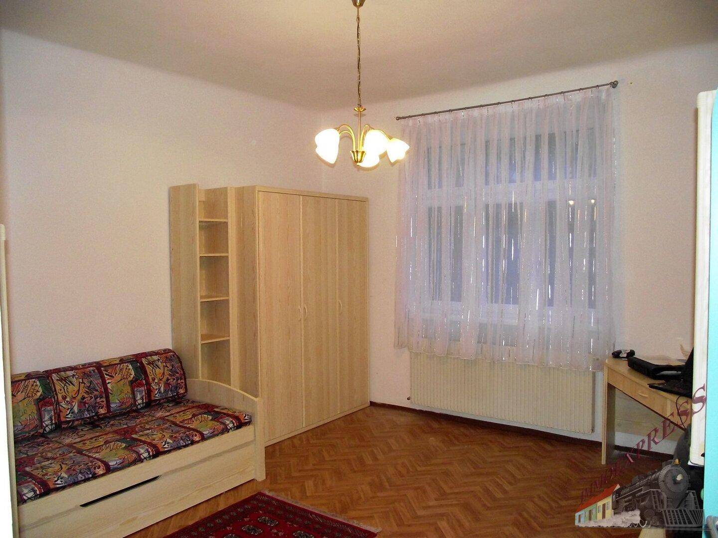 Heller Wohnschlafbereich mit großem Fenster, Schlafsofa und Holzschrank, gut gepflegt.