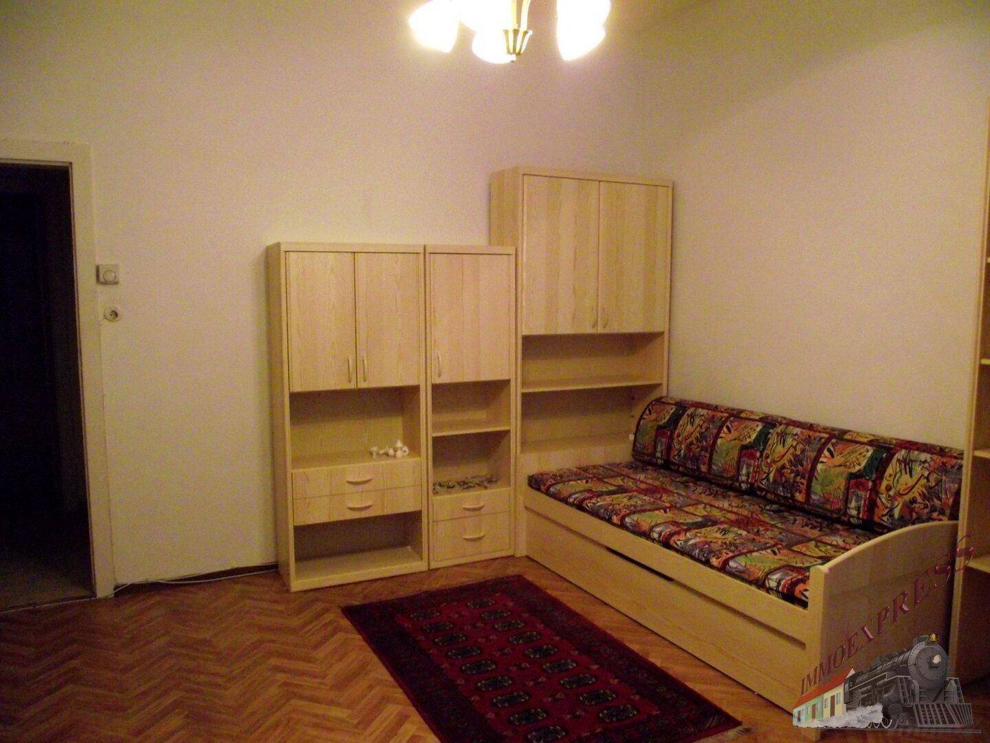 Gemütlicher Wohnschlafbereich mit Schlafsofa, hellen Holzmöbeln und Parkettboden.