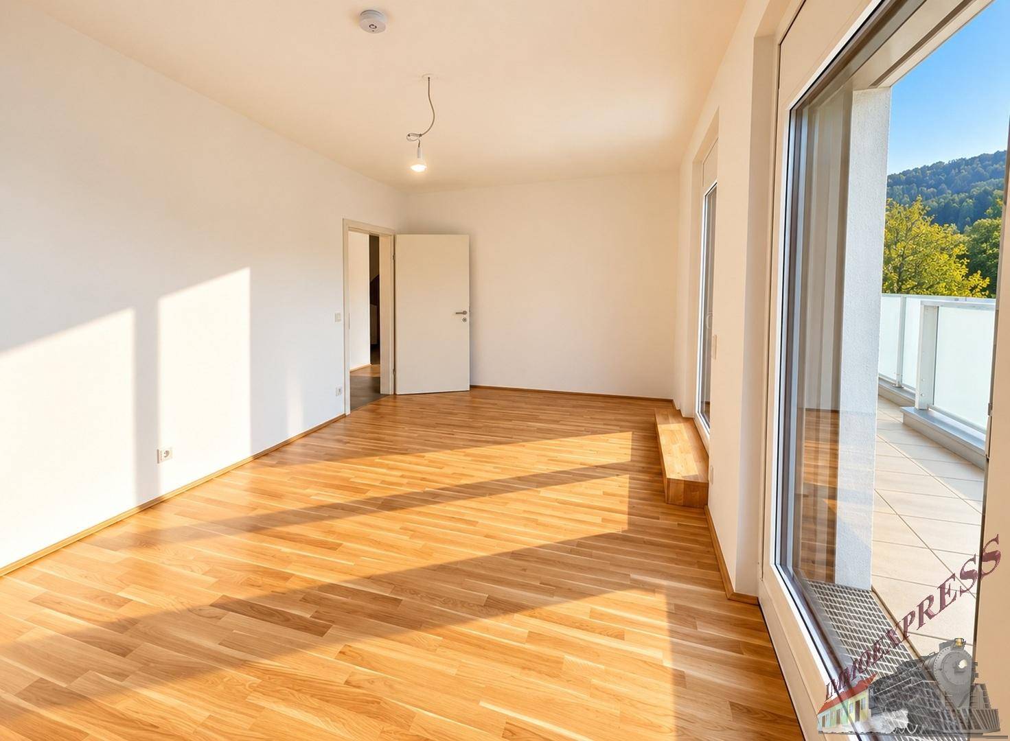 Geräumiger Wohnbereich mit Holzboden und direktem Zugang zur sonnigen Außenterrasse.