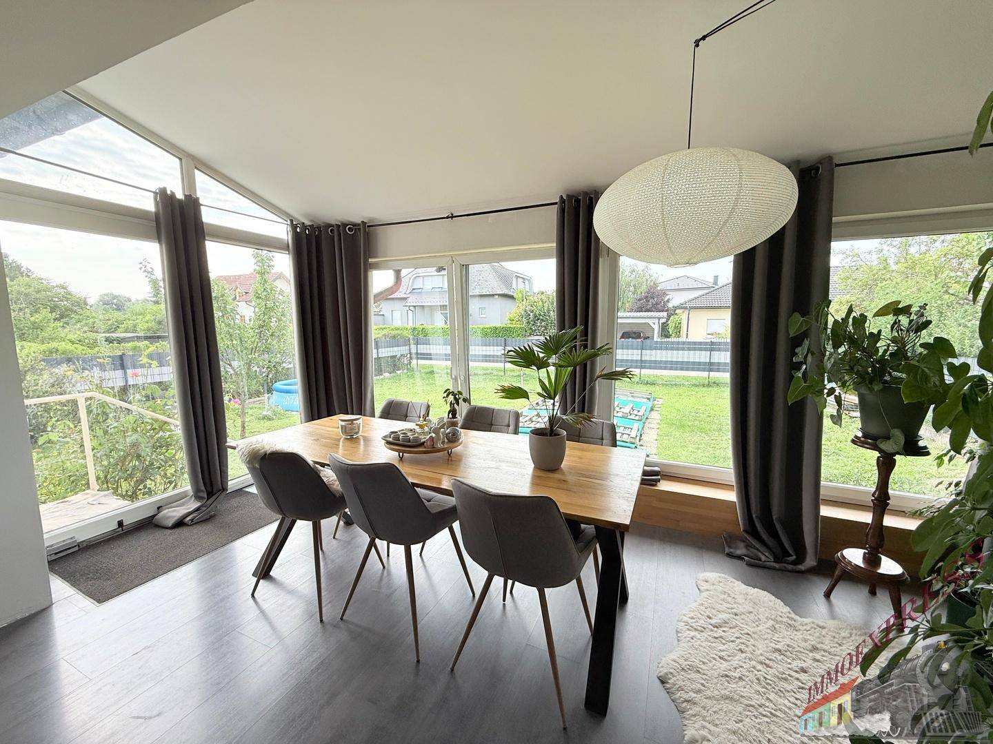 Heller Essbereich mit großem Holztisch, modernen Stühlen und weitem Blick in den Garten.