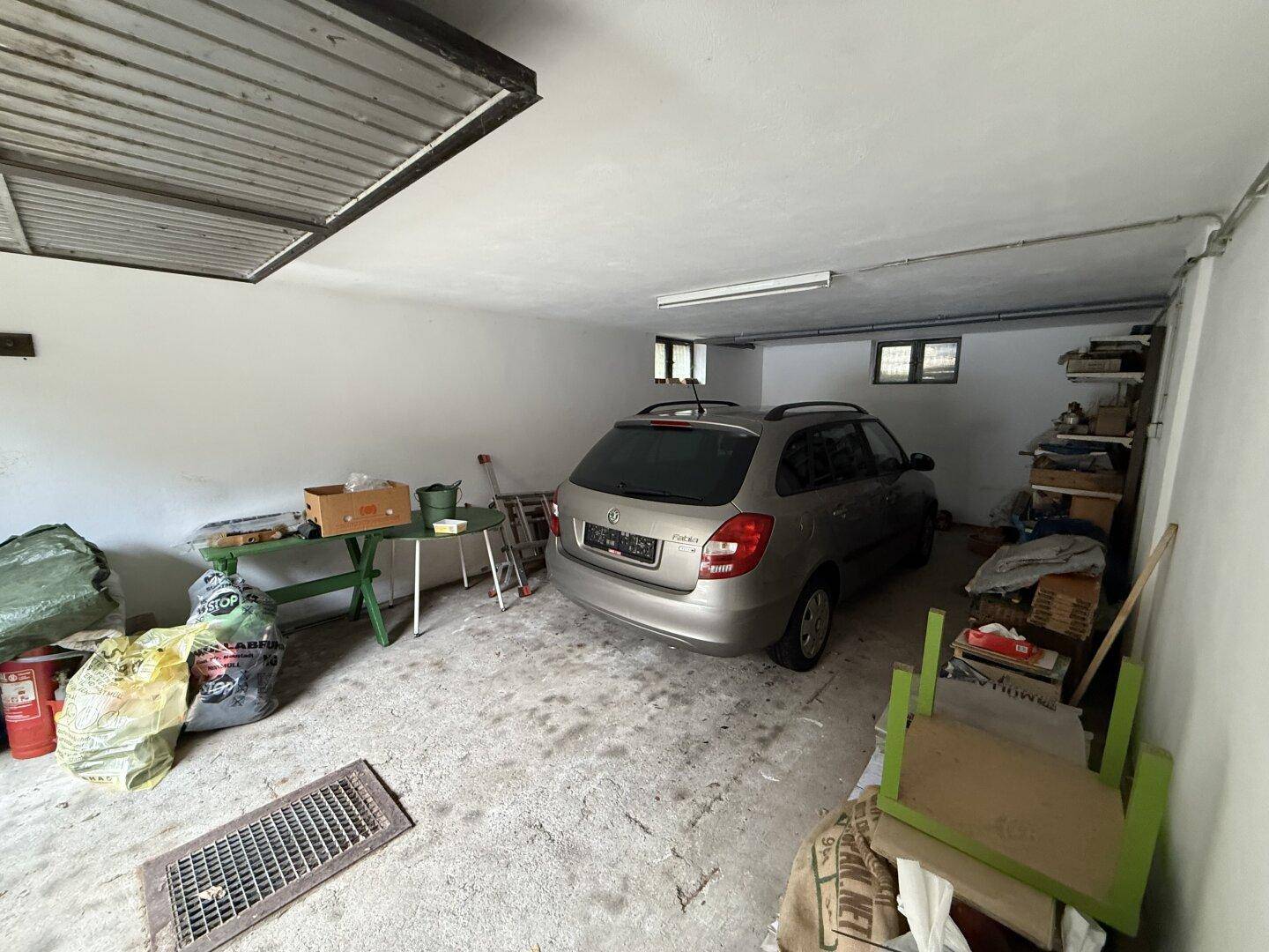 Geräumige Garage mit Platz für ein Fahrzeug und zusätzlichem Stauraum.