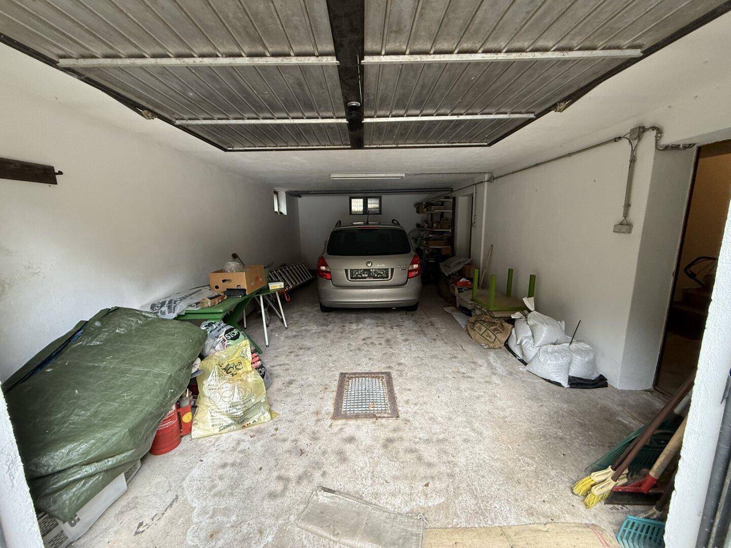 Geräumige Garage mit Platz für ein Fahrzeug und zusätzlichem Stauraum.