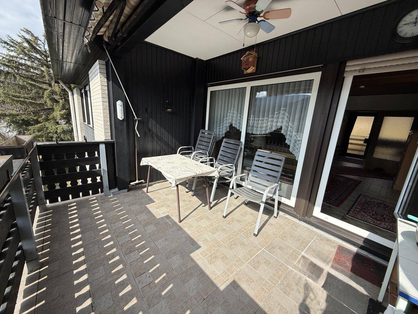 Sonniger Balkon mit Tisch und Stühlen, ideal für entspannte Stunden im Freien.
