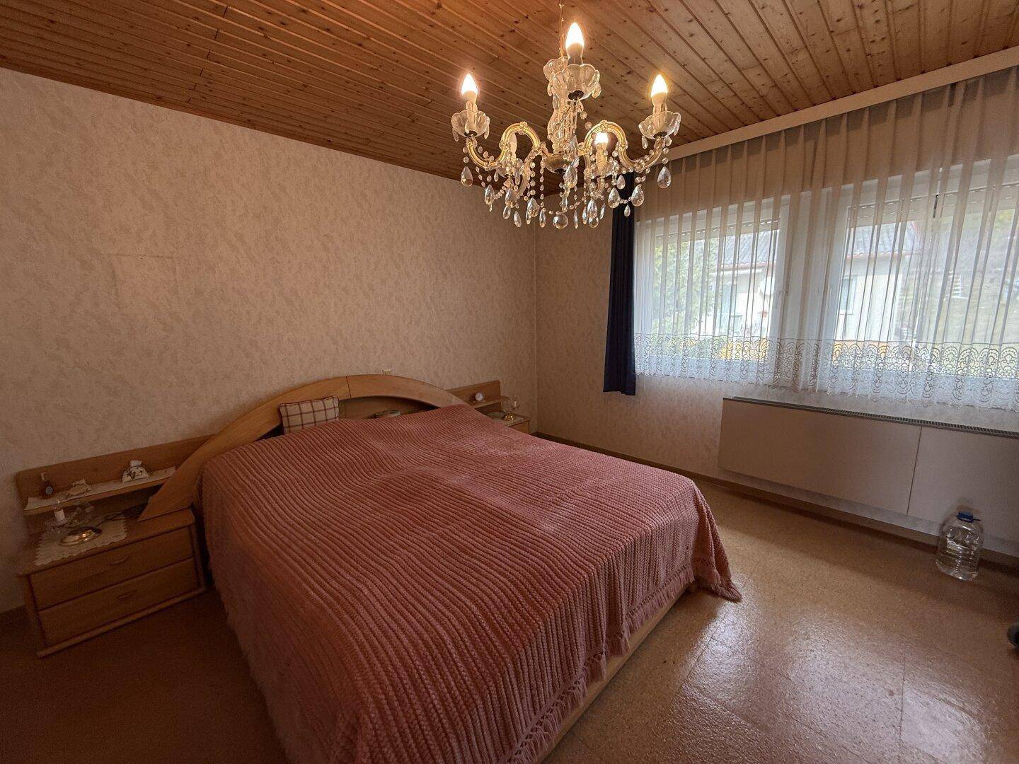 Schlafzimmer mit Doppelbett, Holzdecke und Kronleuchter, hell und geräumig, sehr gemütlich.