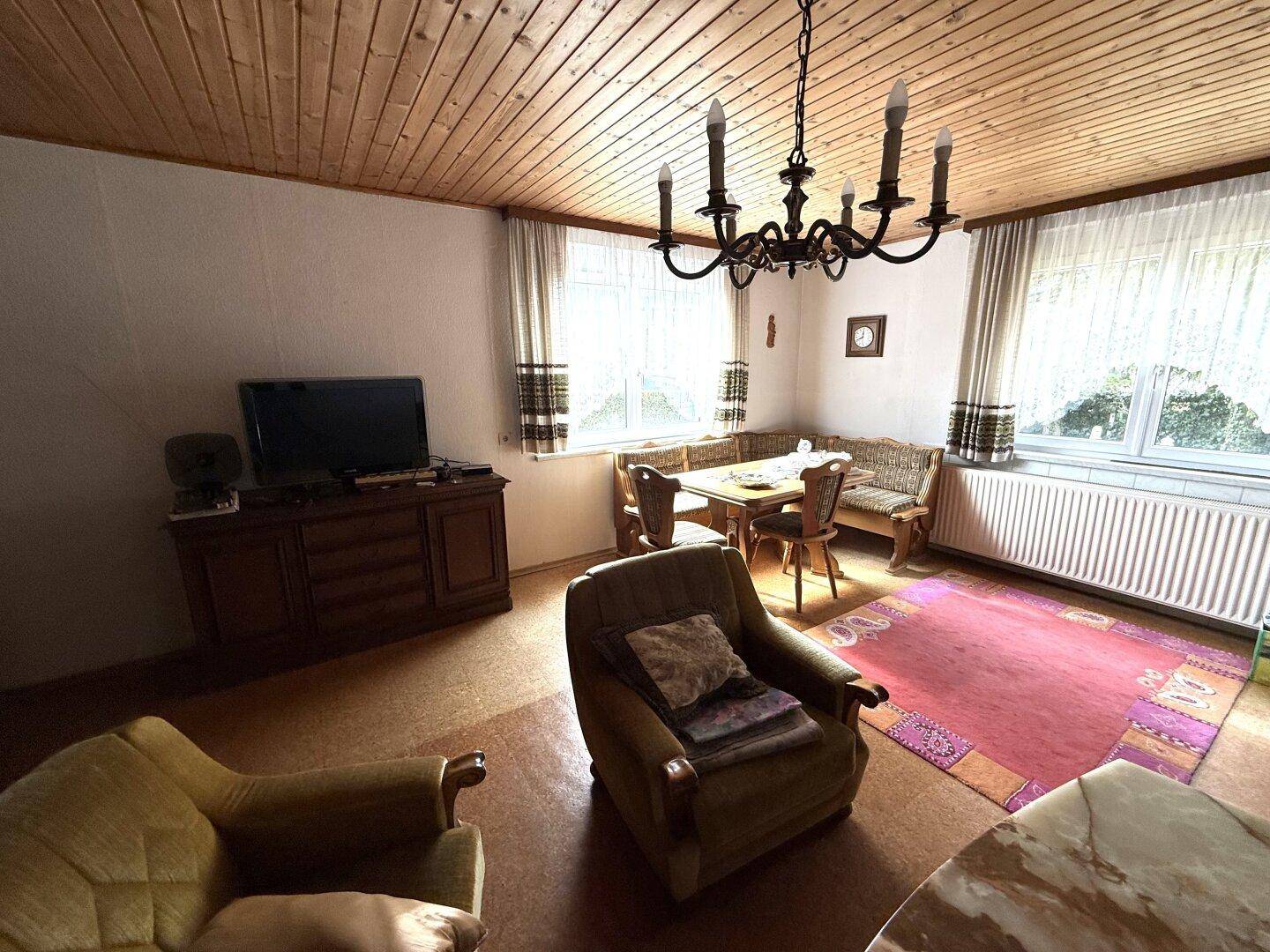 Helles Wohnzimmer mit Sitzgruppe, Esstisch und Blick ins Grüne, sehr einladend.