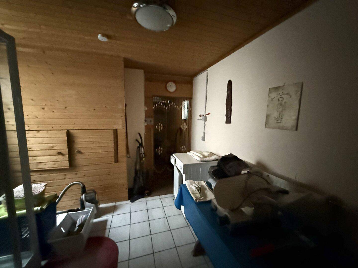 Hauswirtschaftsraum mit Sauna, Fliesenboden und Holzverkleidung an den Wänden, sehr praktisch.