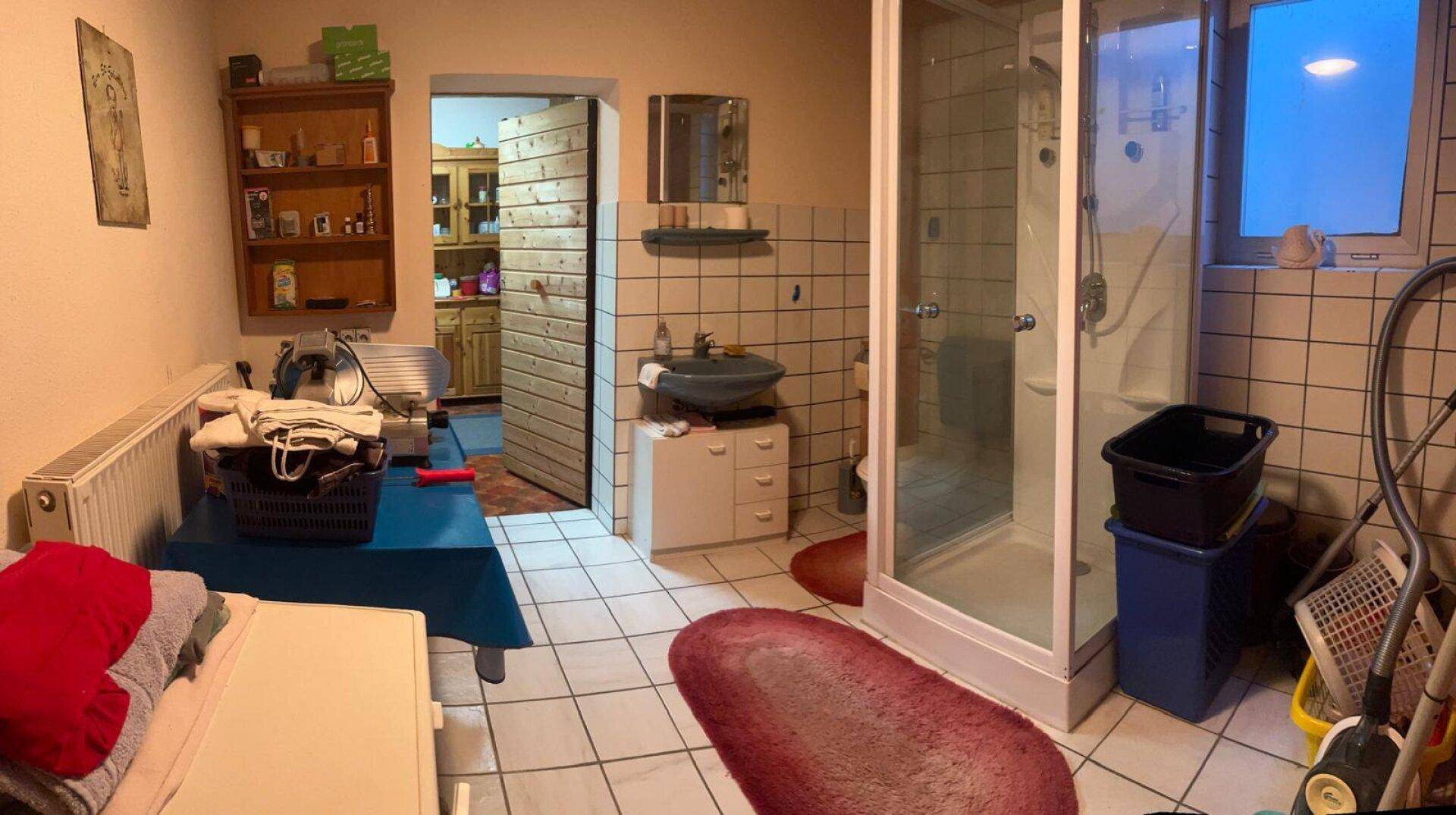 Badezimmer mit Duschkabine, Waschbecken und Fenster, auch als Hauswirtschaftsraum nutzbar.