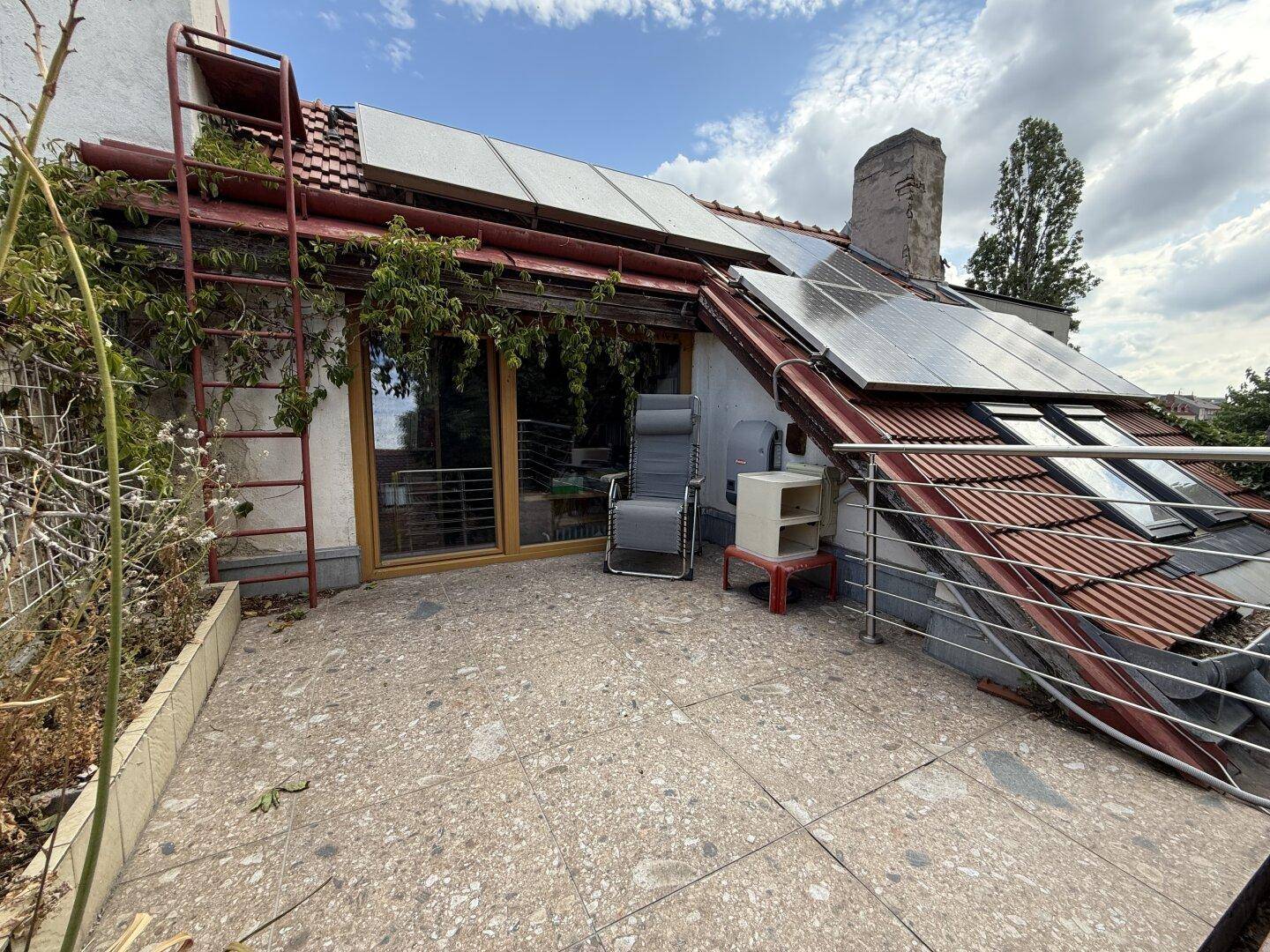 Dachterrasse mit Solarpaneelen, Sitzgelegenheiten und Blick auf die Umgebung.