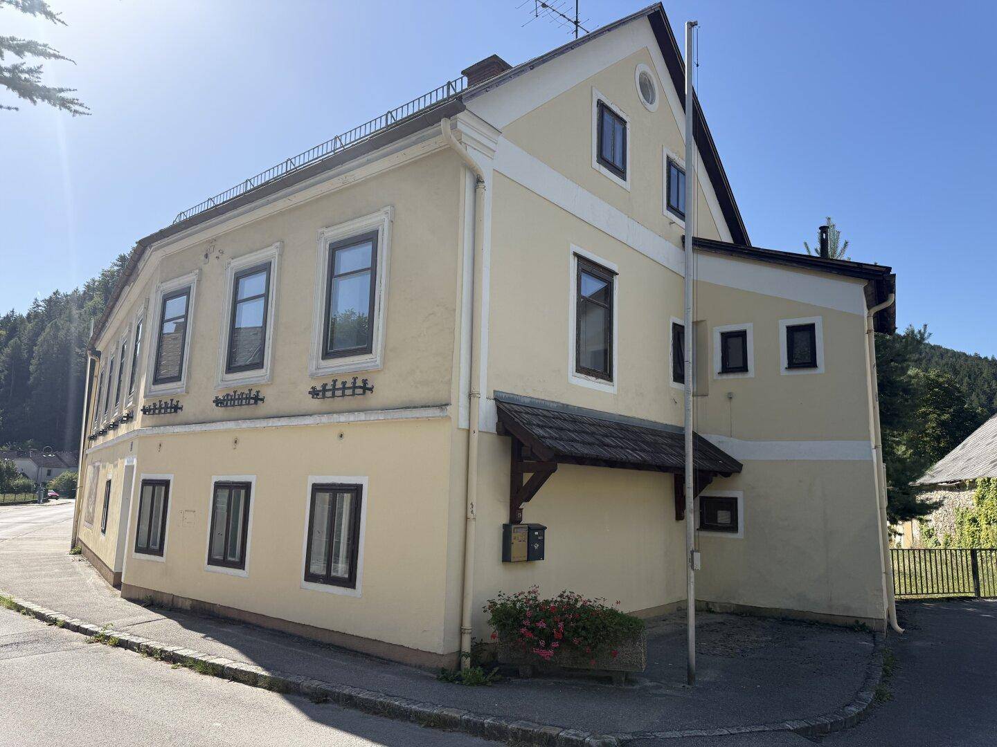 Gelbes Wohnhaus mit Giebeldach und einem kleinen Vordach über dem Eingangsbereich.