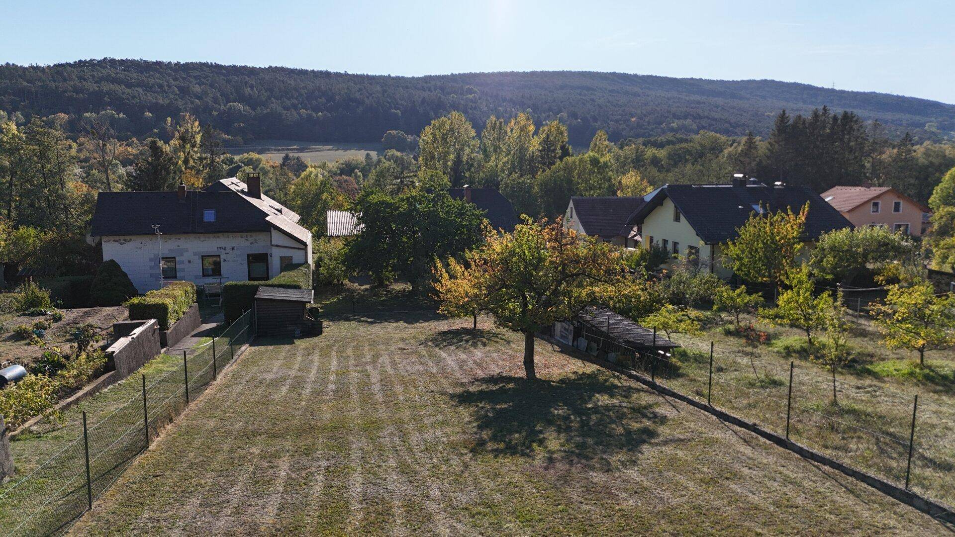 Ausgedehnter Garten mit Obstbäumen und Blick auf die umliegenden Häuser und Landschaft.