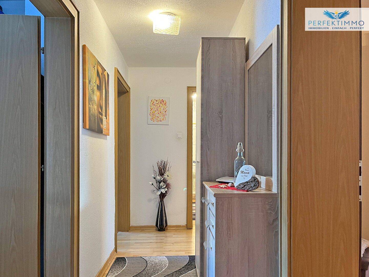 Heller Flur mit Holztüren, Garderobe und dekorativen Akzenten.