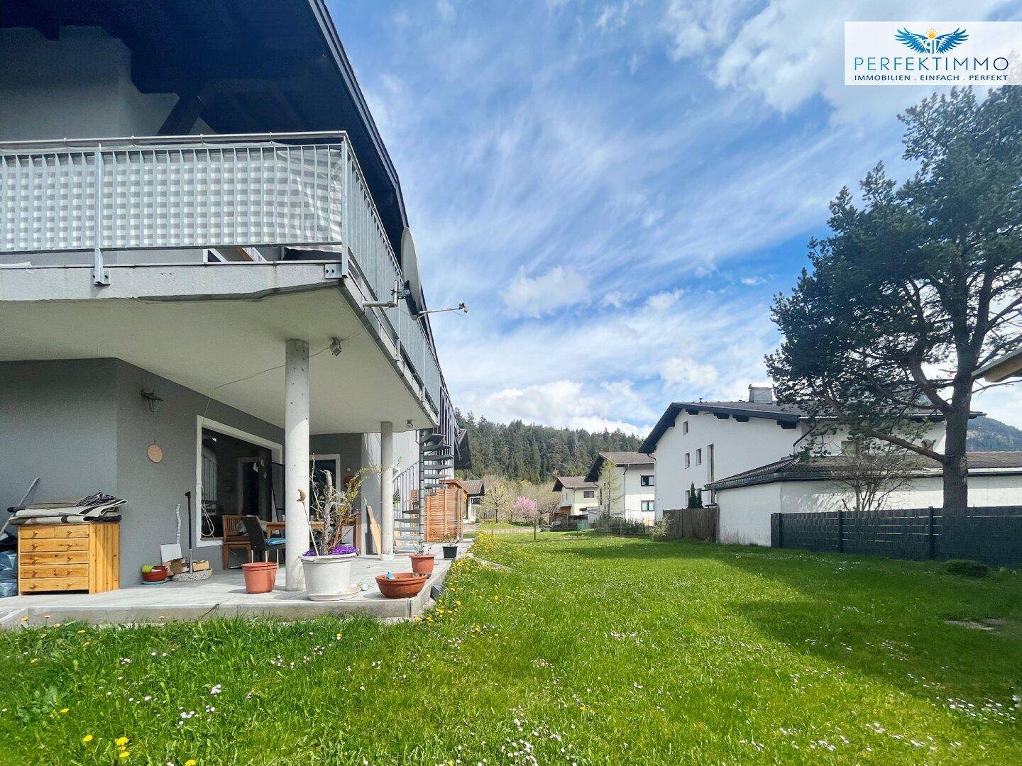 Gepflegter Gartenbereich mit Terrasse, Balkon und Blick auf die umliegende Natur.