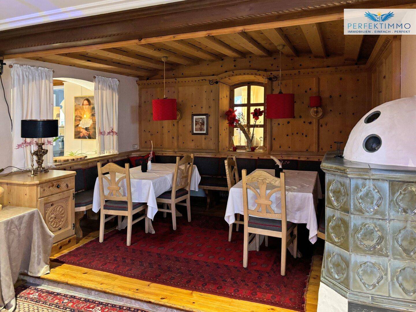 Traditioneller Essbereich mit Holztäfelung, rustikalen Möbeln und einem Kachelofen.