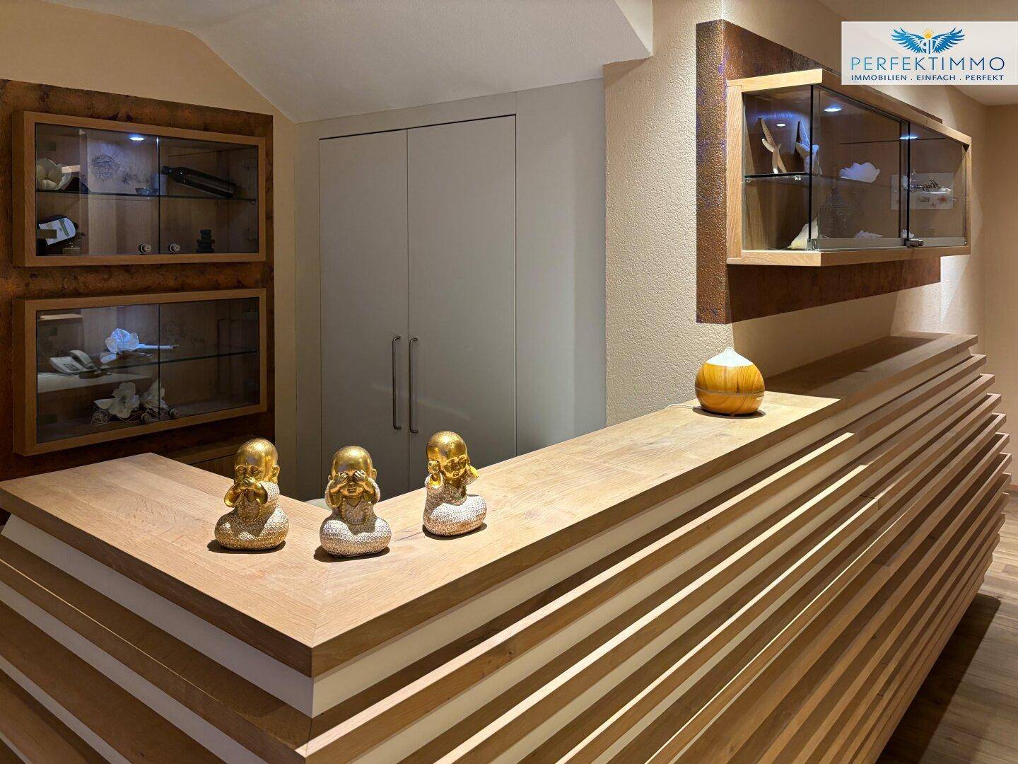 Empfangsbereich mit einer eleganten Holztheke und dekorativen Vitrinen.