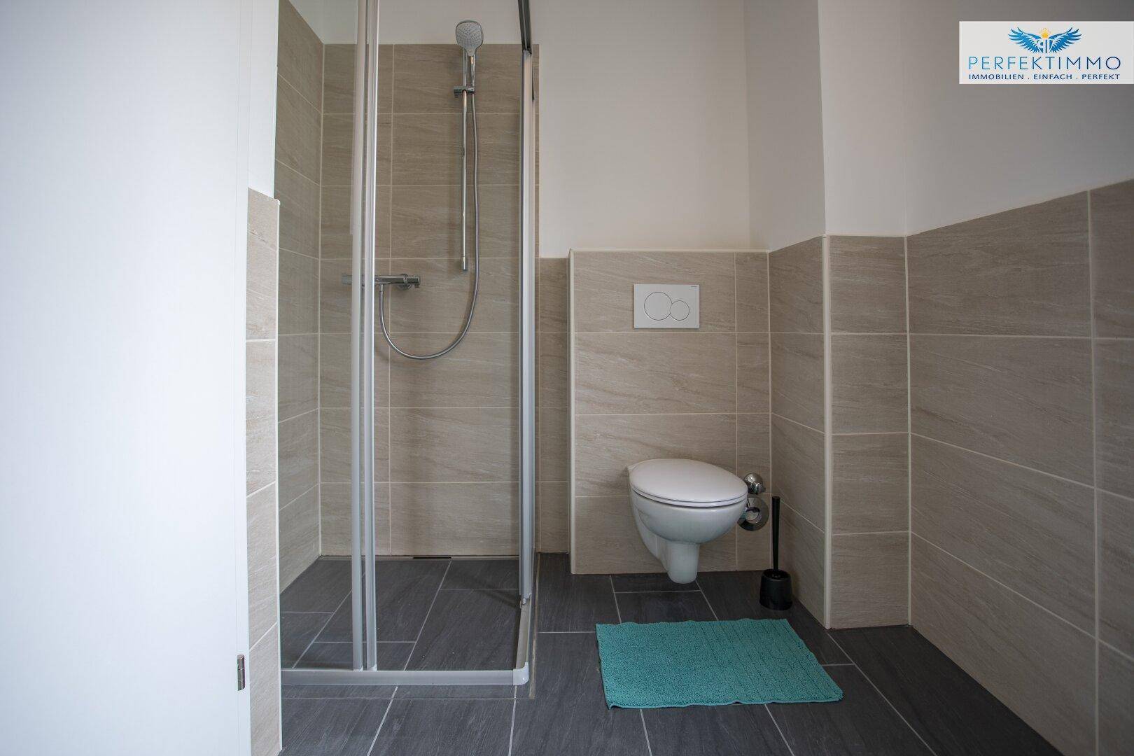 Modernes Badezimmer mit ebenerdiger Dusche und Wand-WC.
