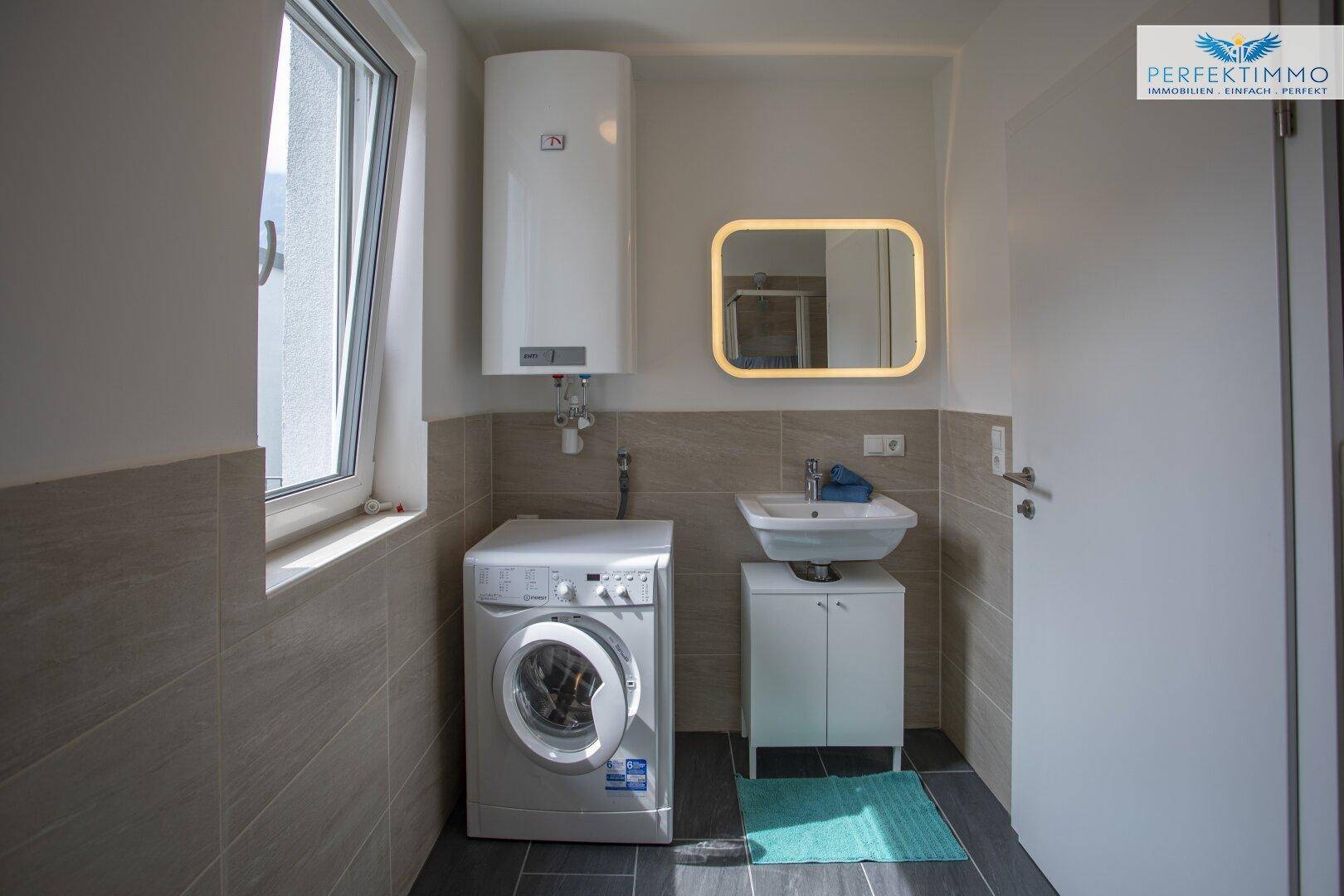 Badezimmer mit Waschbecken, Waschmaschine und Fenster für natürliche Belüftung.