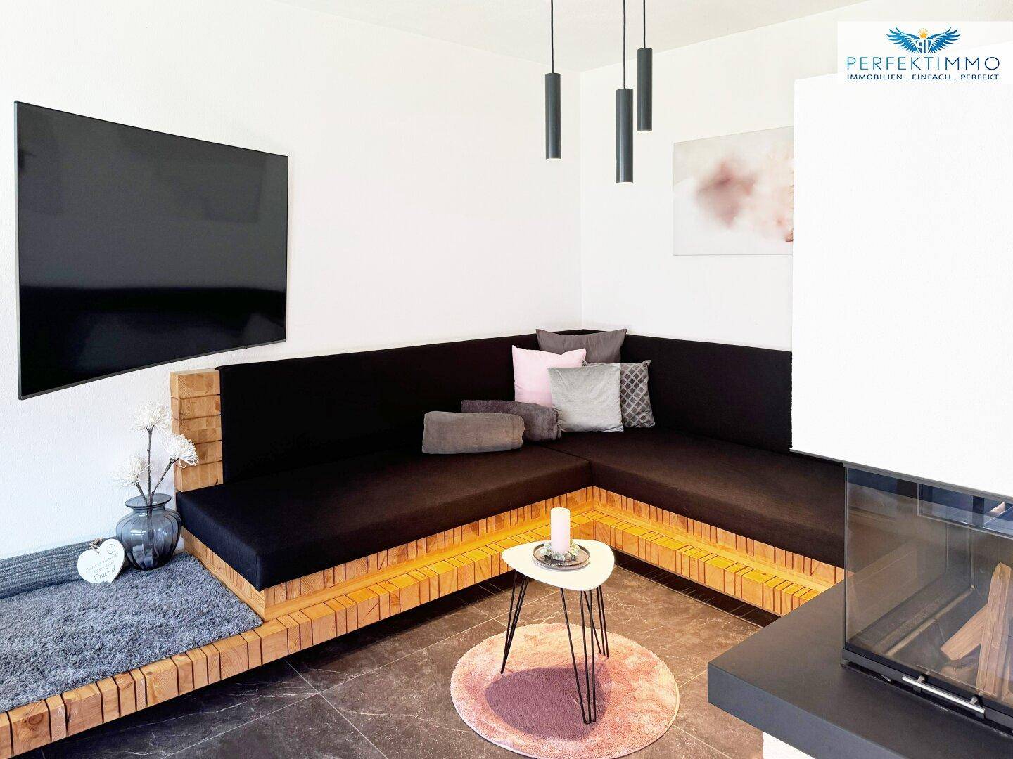 Moderner Wohnbereich mit Kamin, bequemer Sitzecke und stilvoller Beleuchtung.