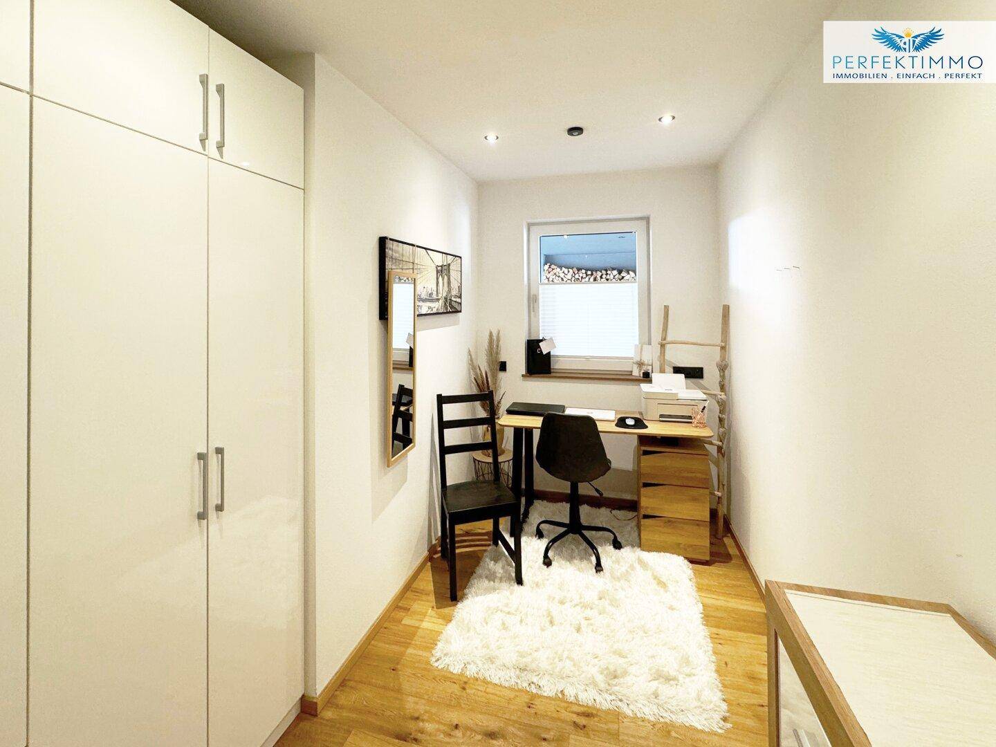 Helles Arbeitszimmer mit weißem Schrank, Holzboden und Fenster.