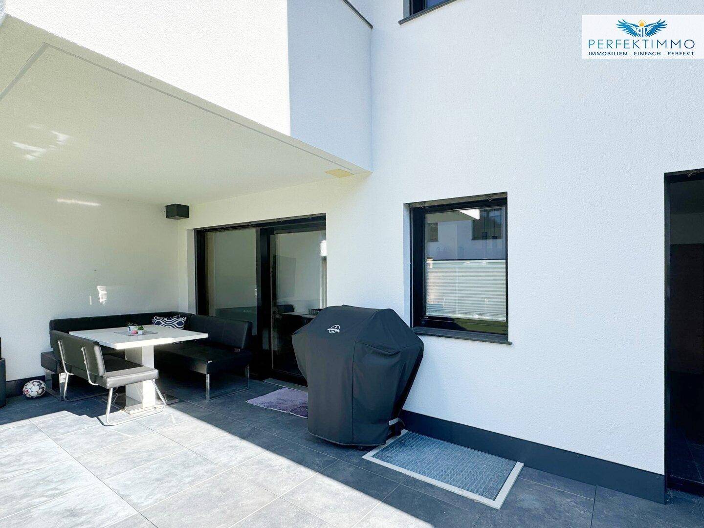 Überdachte Terrasse mit Sitzgelegenheiten und Grillbereich, ideal für entspannte Stunden.