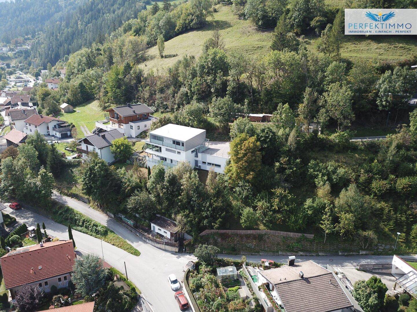 Weitläufige Luftaufnahme einer Wohnsiedlung mit dem modernen Gebäude in einer grünen Umgebung.
