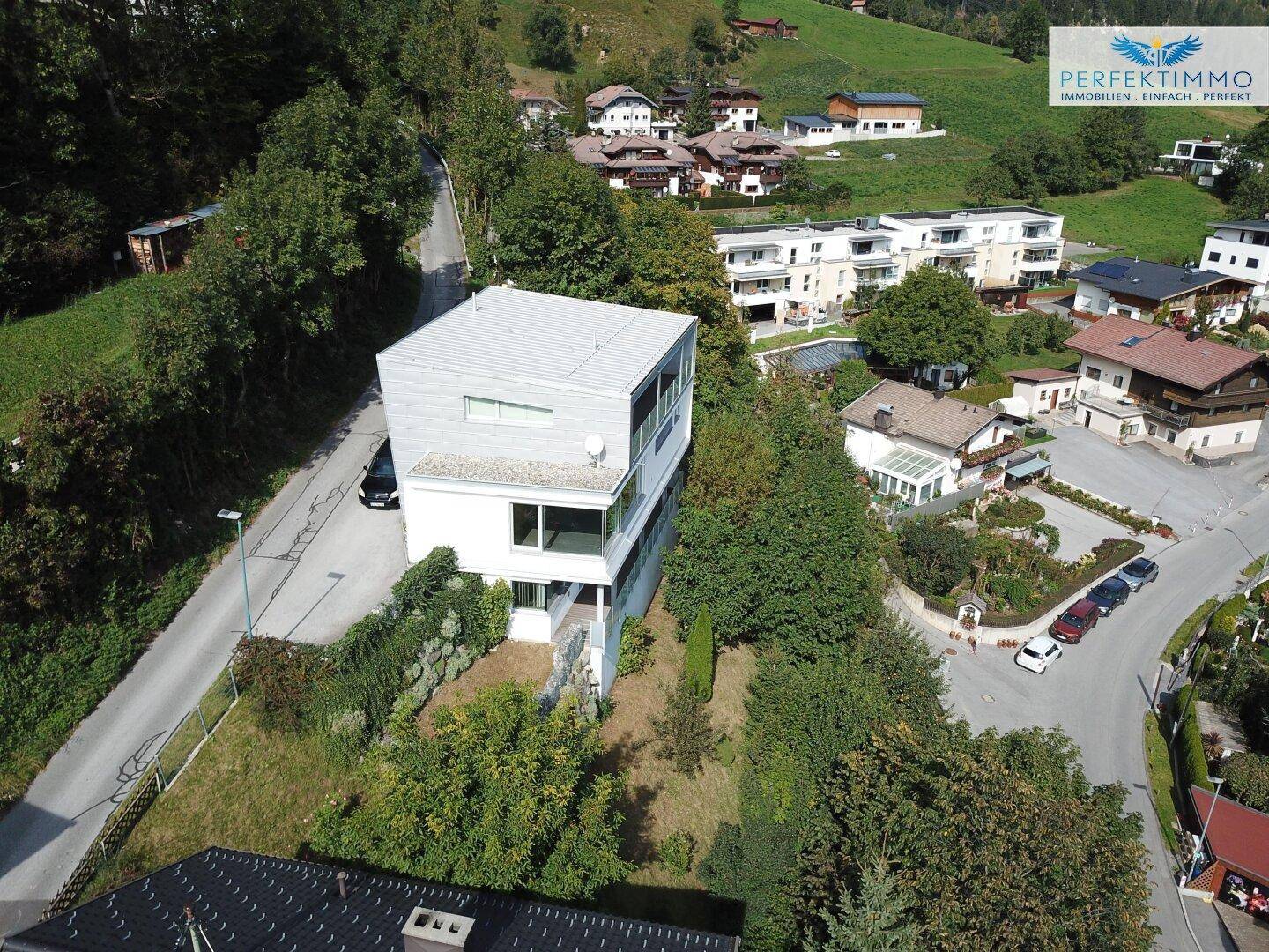 Luftaufnahme einer Wohnsiedlung mit dem modernen Gebäude, umgeben von Straßen und Bäumen.