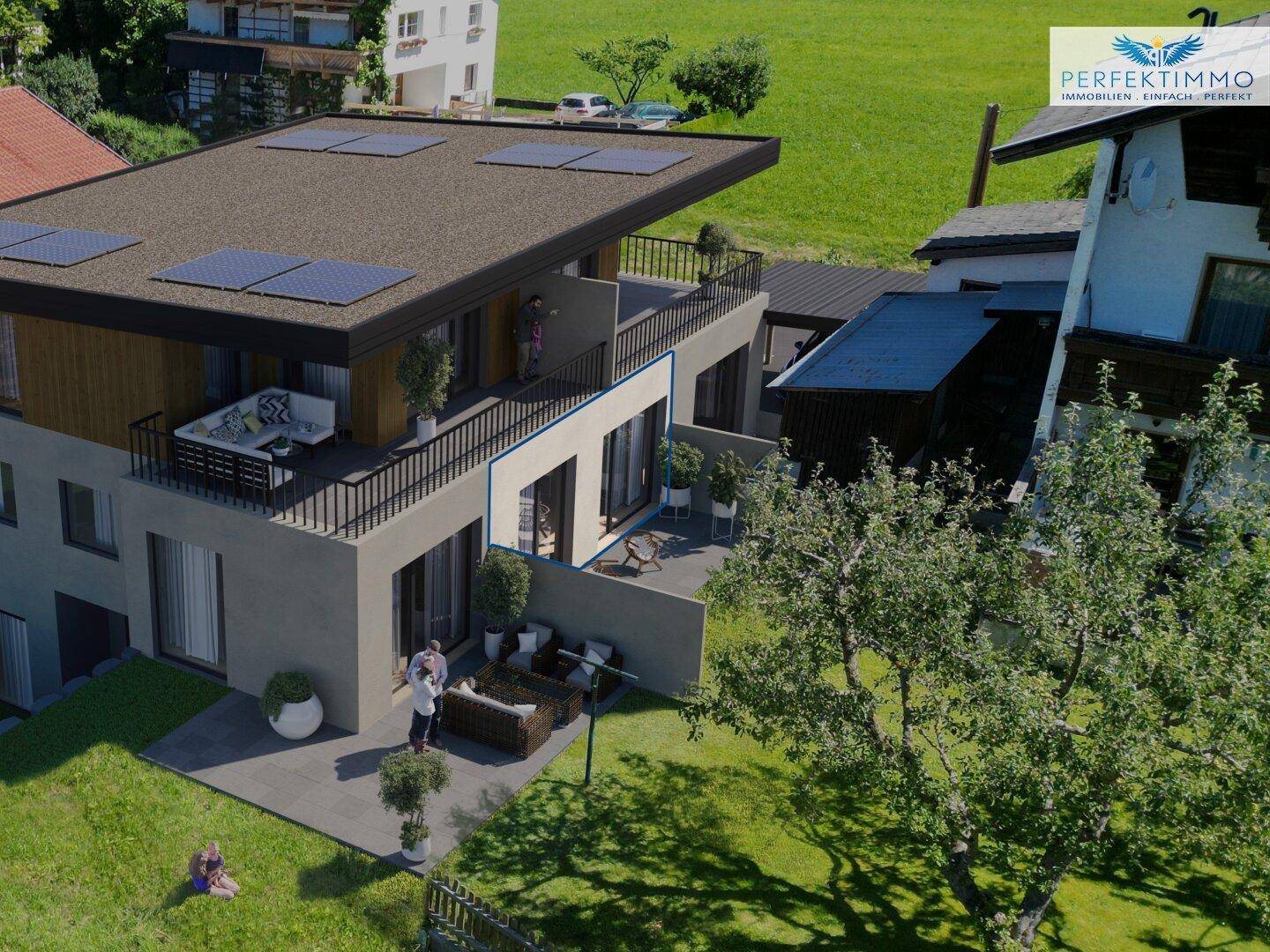 Luftaufnahme eines modernen Wohnhauses mit Terrassen, Balkonen und Solaranlage in grüner Umgebung.