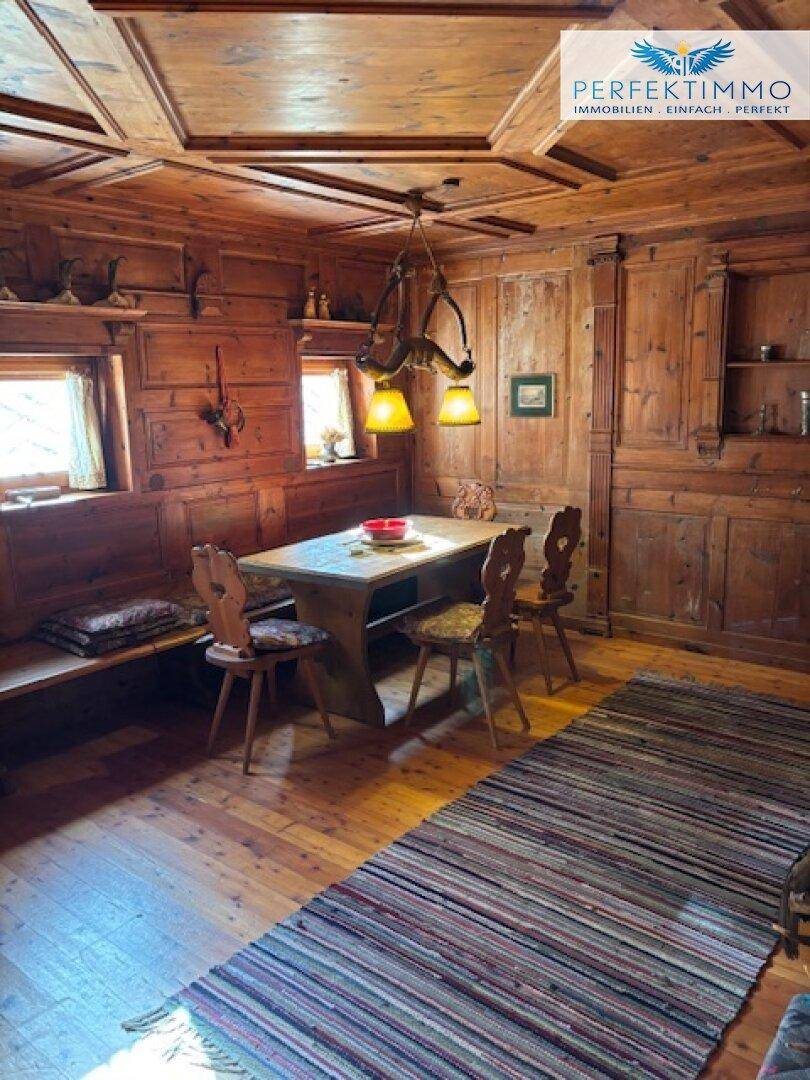 Traditionelles Esszimmer mit rustikaler Holzausstattung, gemütlicher Sitzecke und warmem Licht.