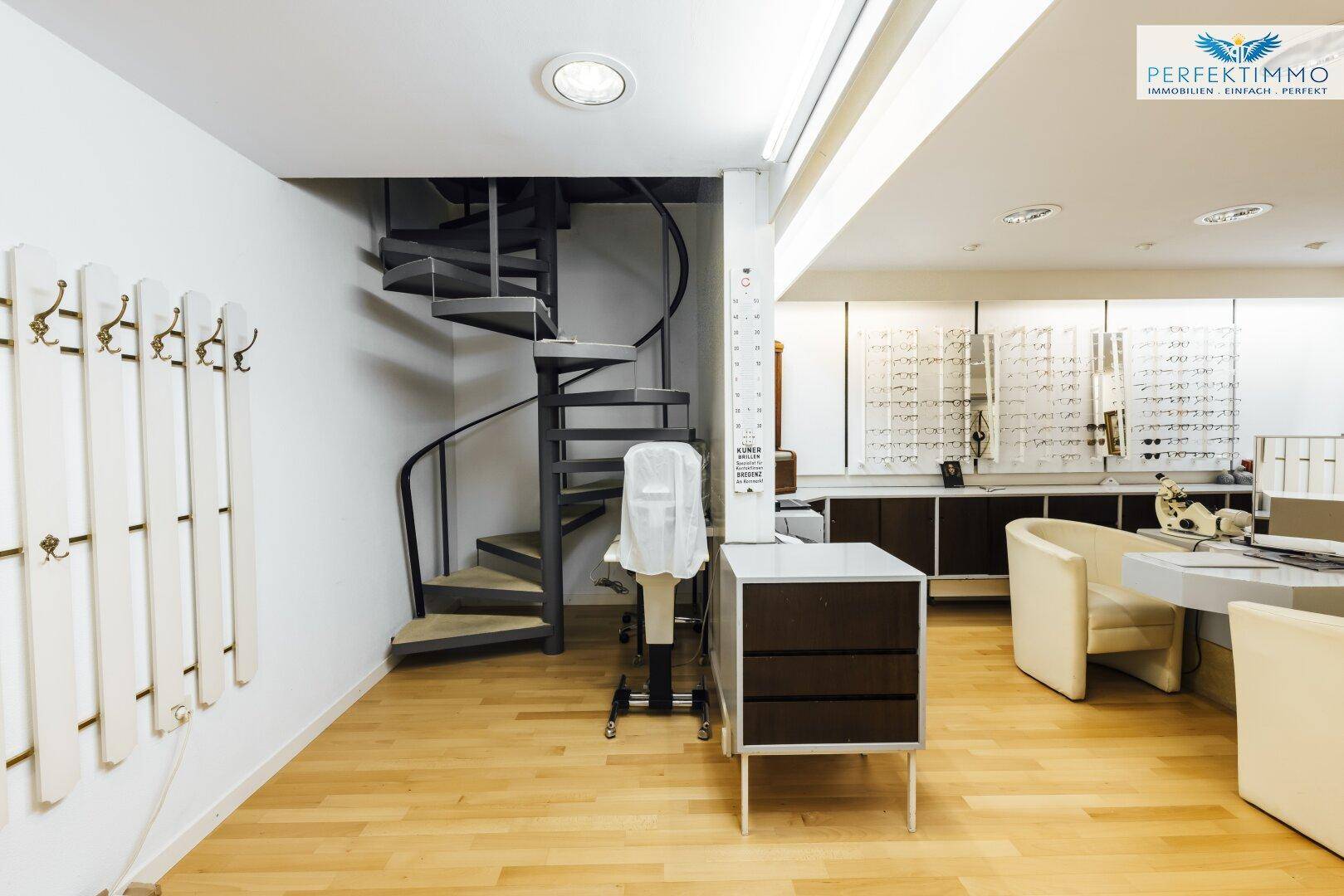 Verkaufsraum mit Wendeltreppe, Holzboden und modernen Präsentationsflächen.