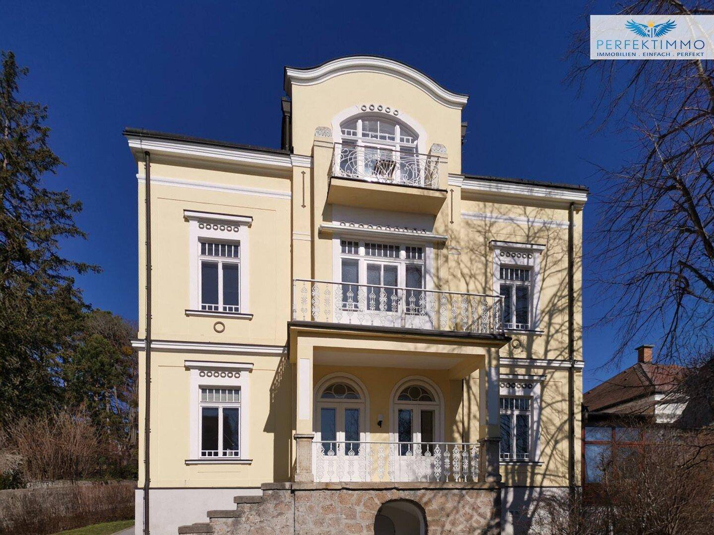 Detailansicht der historischen Villa mit mehreren Balkonen und kunstvollen Geländern.