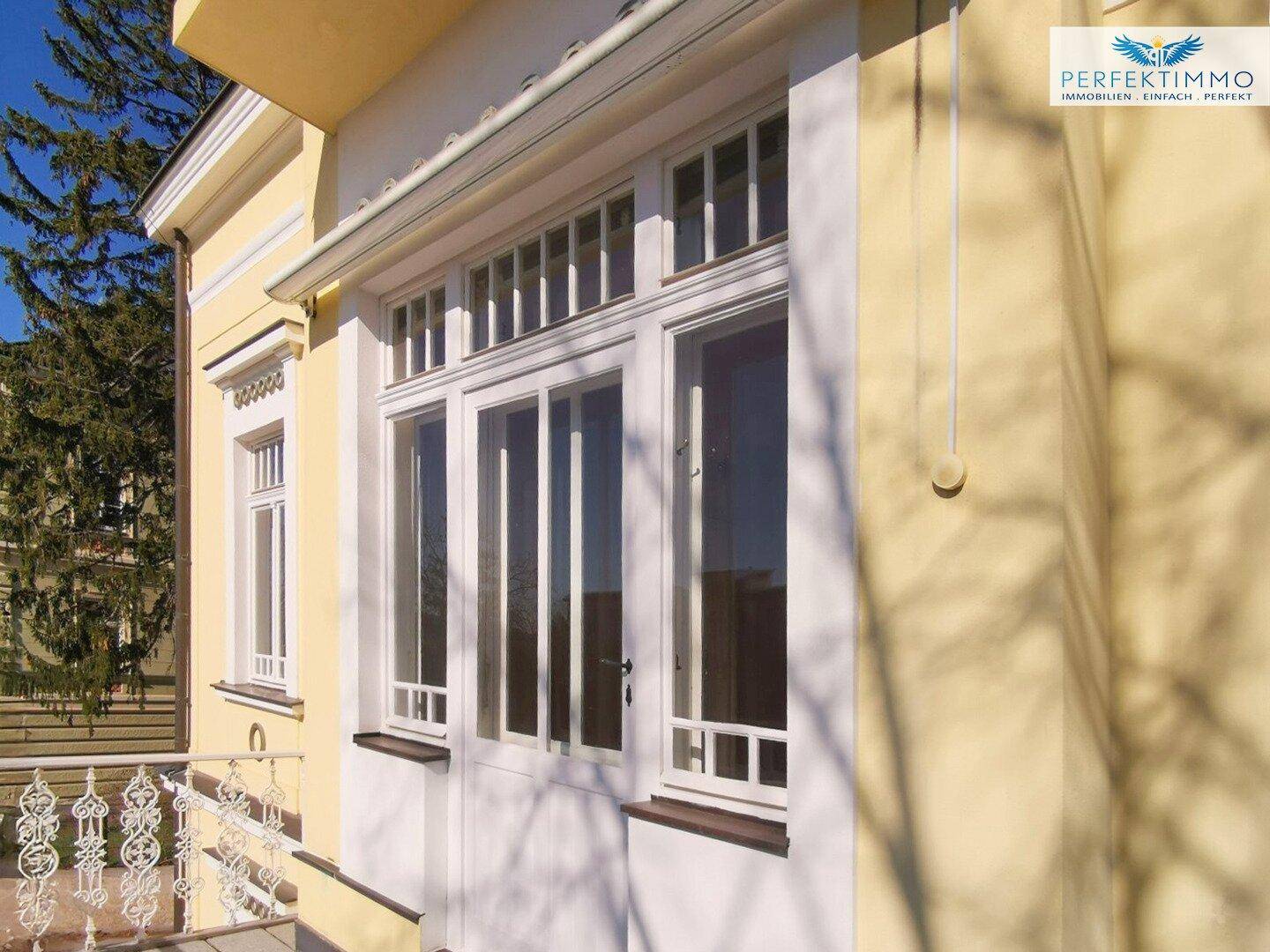 Große Fenster und Balkontür mit Sprossen, die viel Tageslicht in die Innenräume lassen.