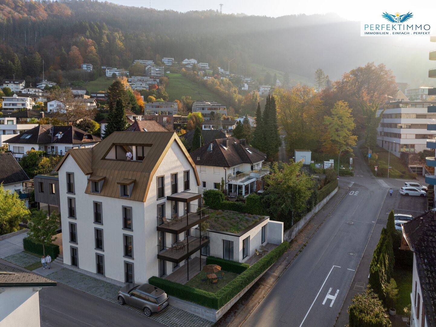 Luftaufnahme eines modernen Wohngebäudes in einer grünen Wohngegend mit Herbstbäumen.