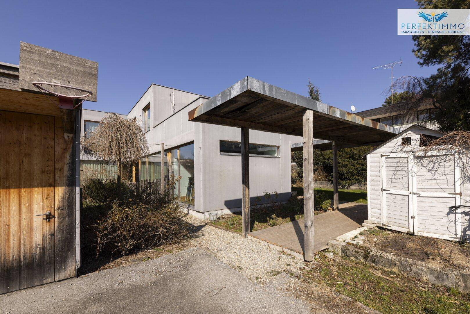 Außenbereich mit Carport, Garage und Gartenhaus.
