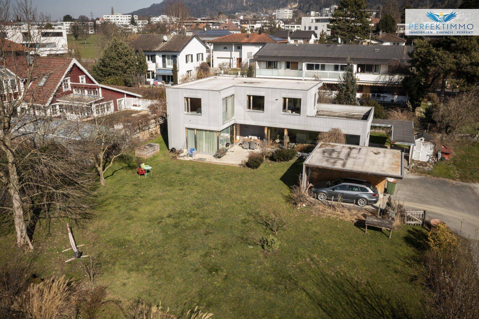 Luftaufnahme des Hauses mit großem Garten und Carport in sonniger Lage.