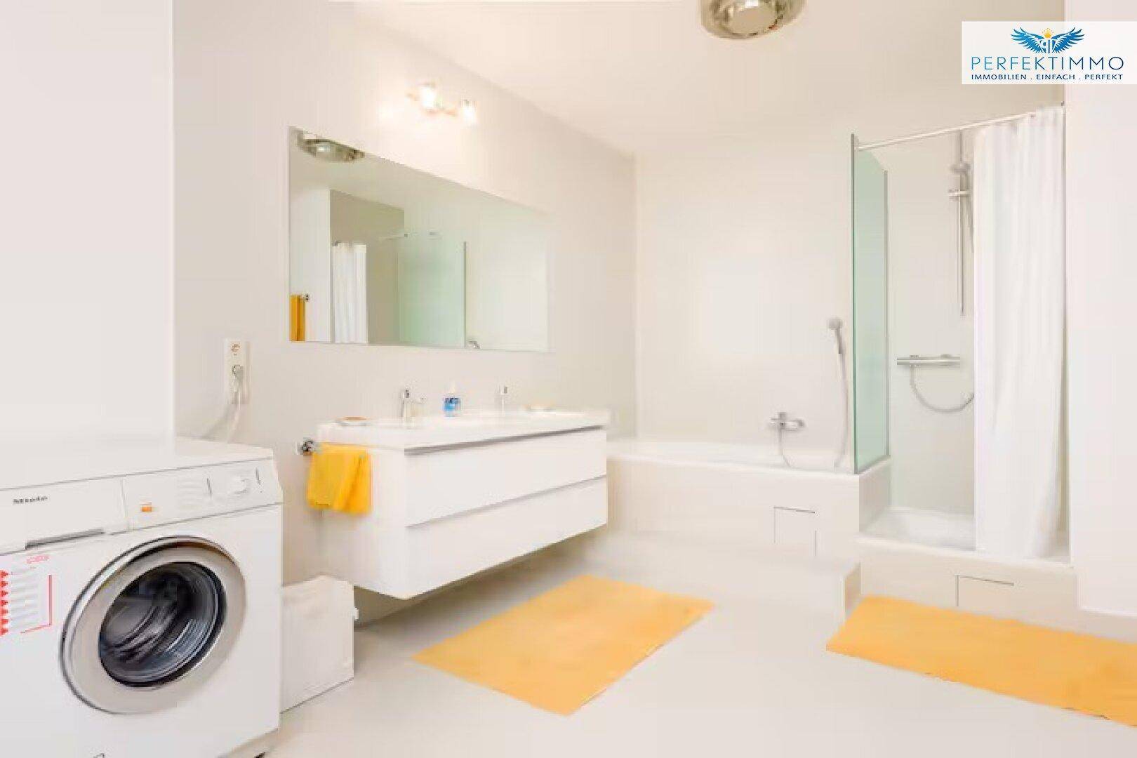 Geräumiges Badezimmer mit Badewanne, Duschkabine, Doppelwaschbecken und Waschmaschine.