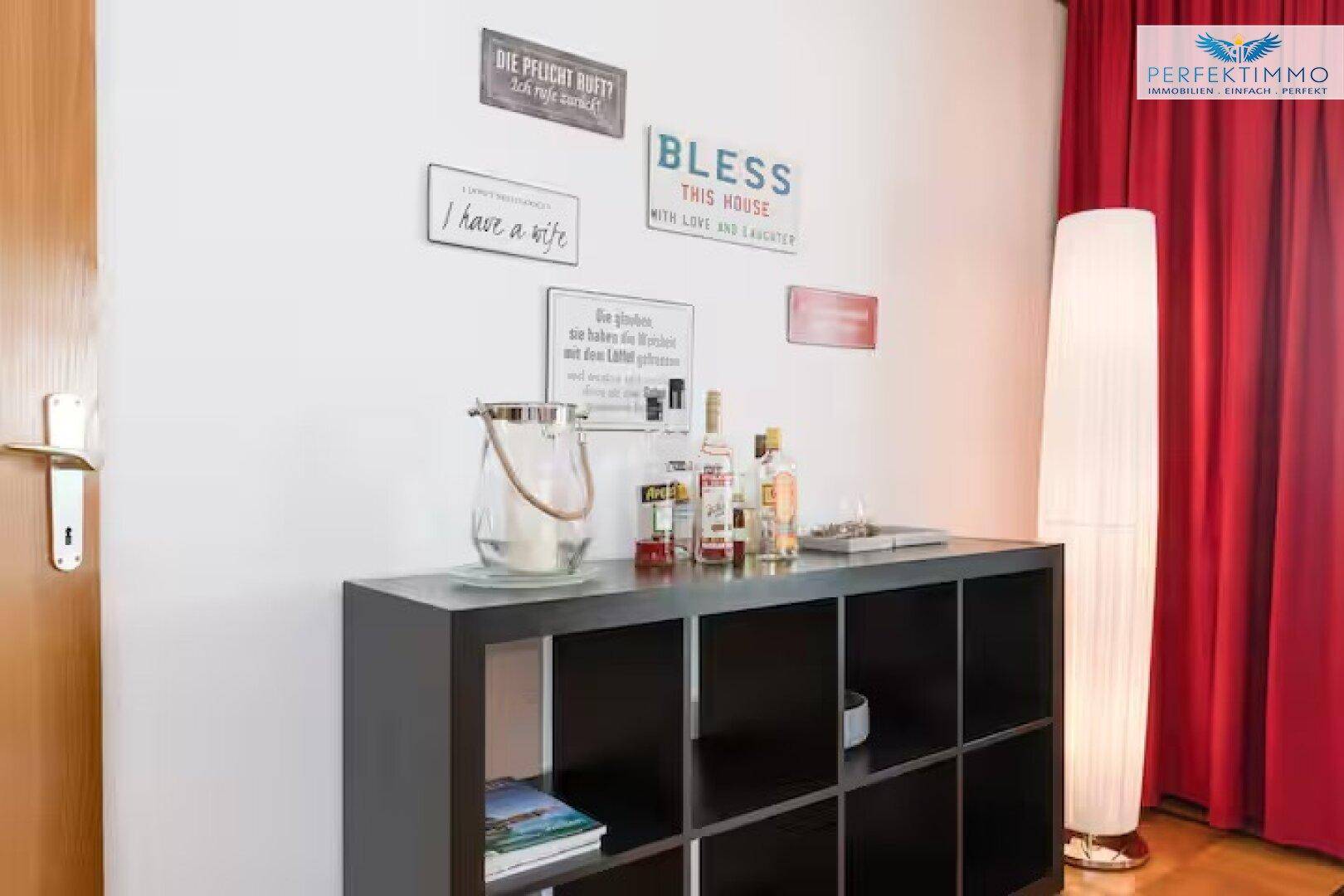 Dekorative Bar-Ecke mit Flaschen und einem Regal in einem Wohnbereich.