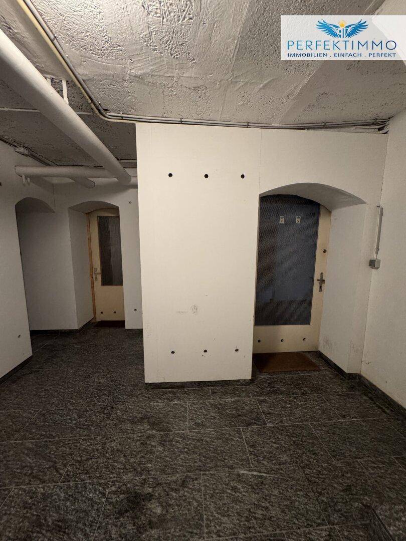 Kellerflur mit robustem Granitboden und mehreren Türen zu den einzelnen Abteilen.