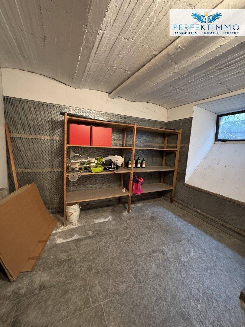 Geräumiger Lagerraum im Keller mit Holzregalen und einem kleinen Fenster für Tageslicht.