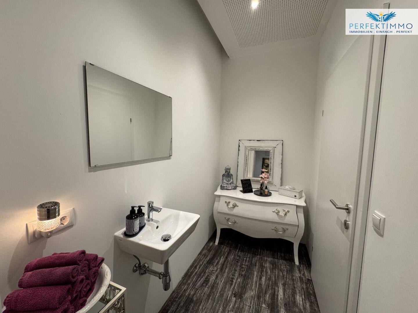 Badezimmer oder Gäste-WC mit Waschbecken, Spiegel und einem dekorativen Schrank.