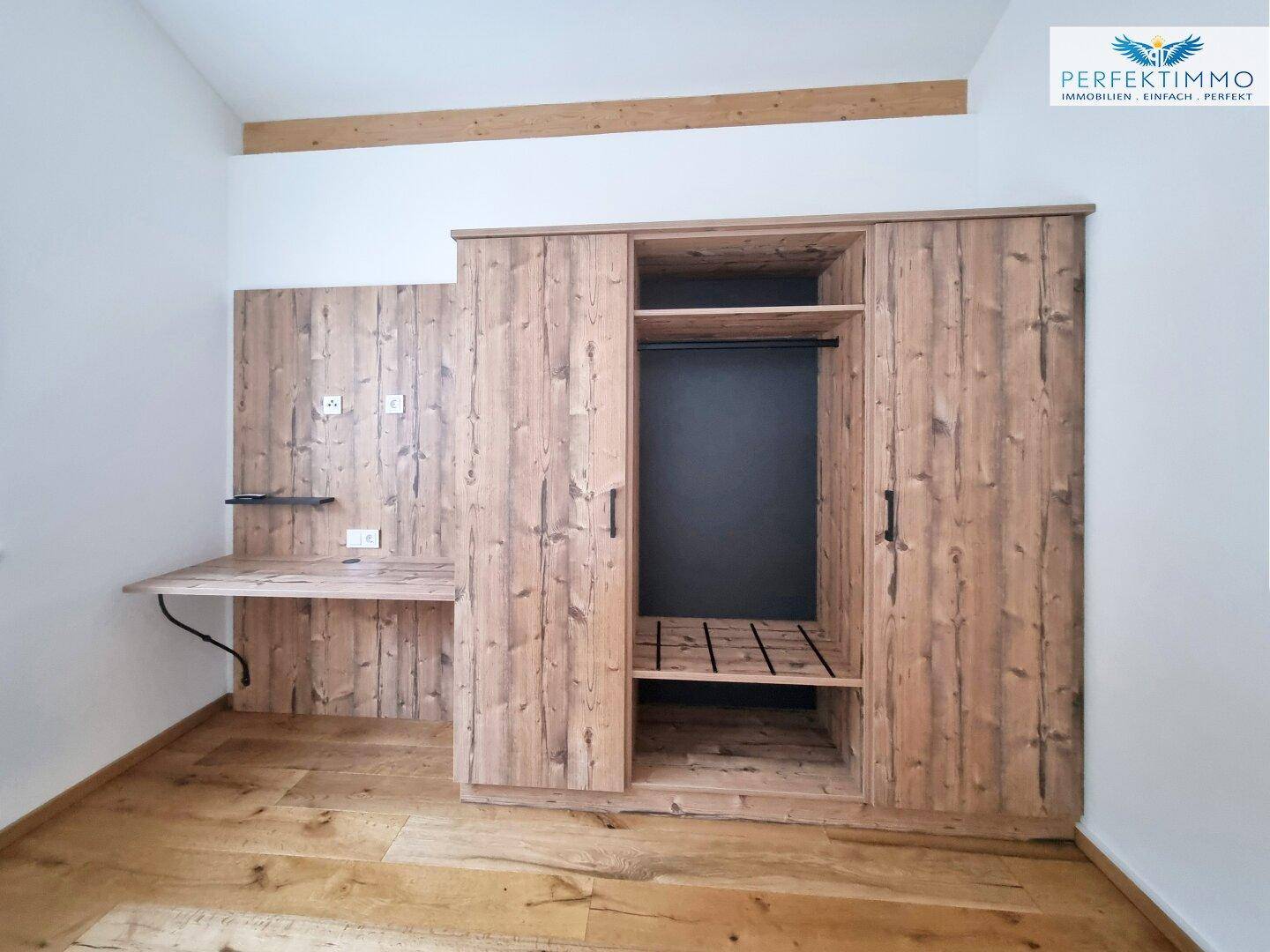 Zimmer mit Holzboden und integriertem Schrank sowie Schreibtisch, ideal als Gäste- oder Arbeitszimmer.