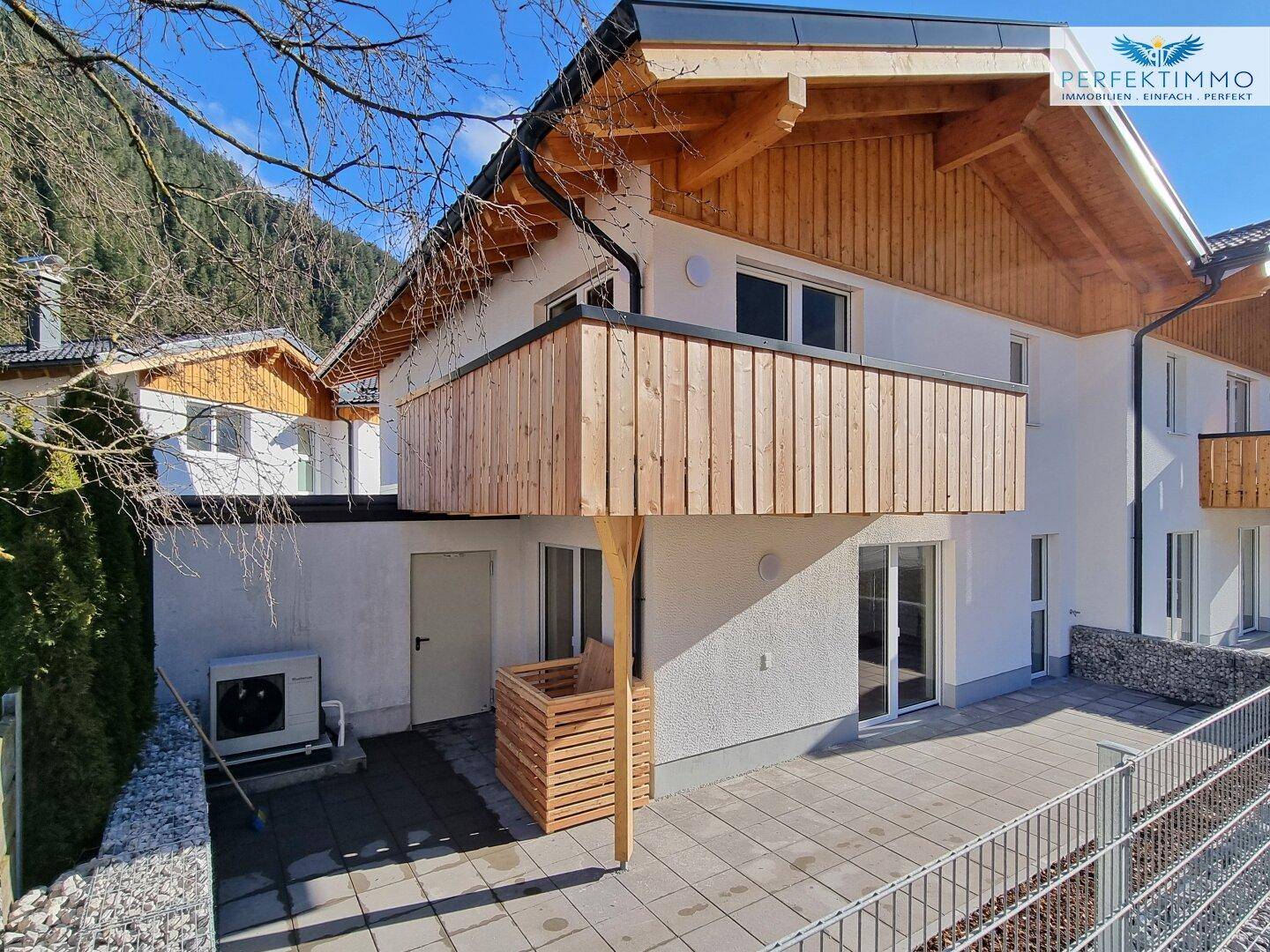 Geräumige Terrasse mit Steinplatten und Zugang zum Garten, ideal für Entspannung im Freien.