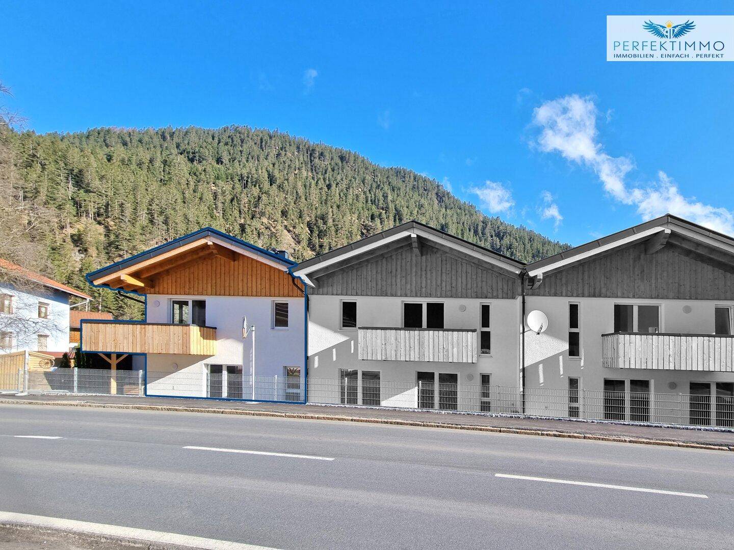 Moderne Architektur mit Holzdetails und großen Fenstern, eingebettet in die Berglandschaft.