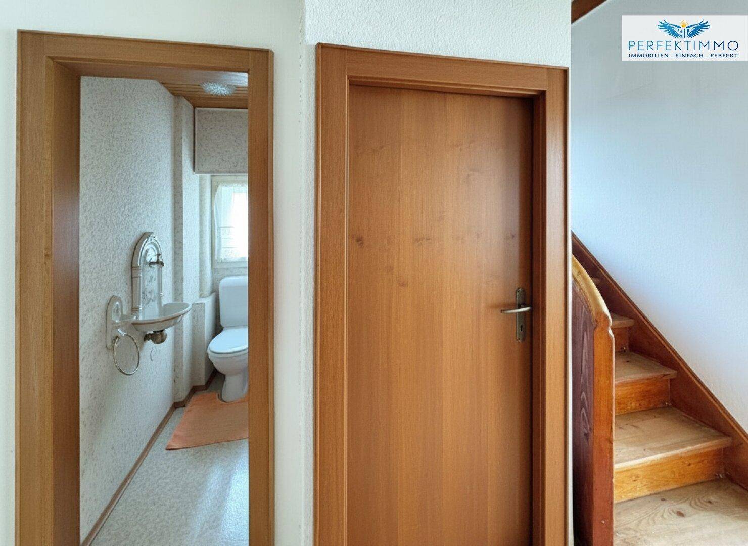 Kleines Gäste-WC mit Waschbecken und Toilette, funktional und einfach gehalten.